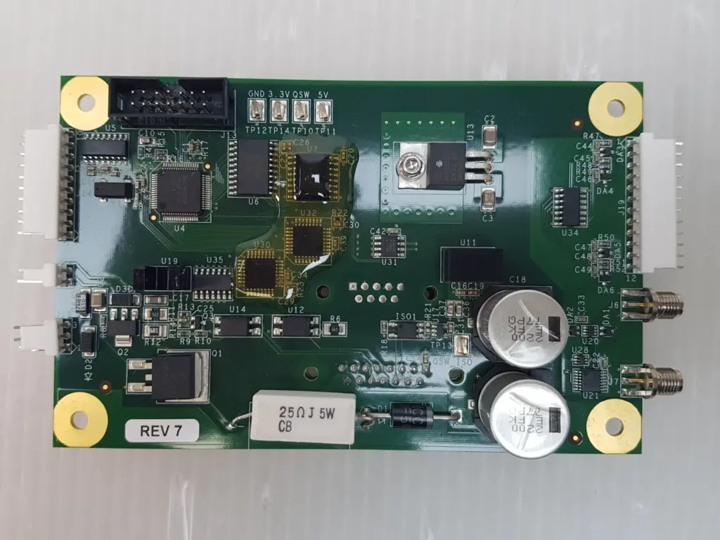 Circuit board ASSY 024-A021 top view with REV 7 sticker, capacitors and SMA connectors