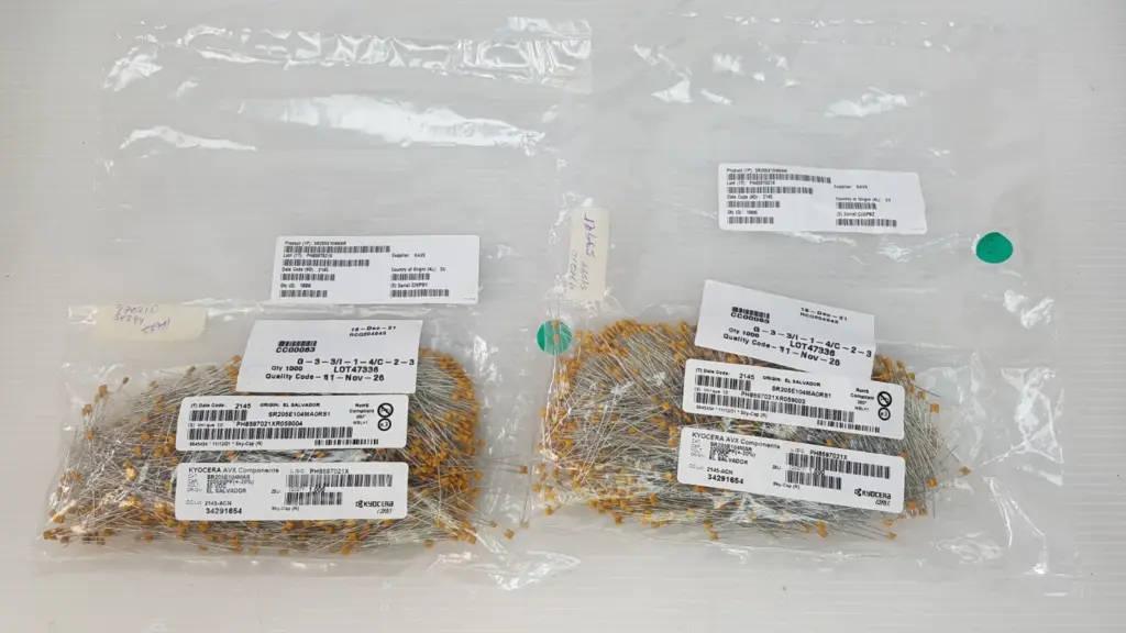 Two factory bags of Kyocera AVX SR205E104MAR radial ceramic capacitors, 1,000 pcs each