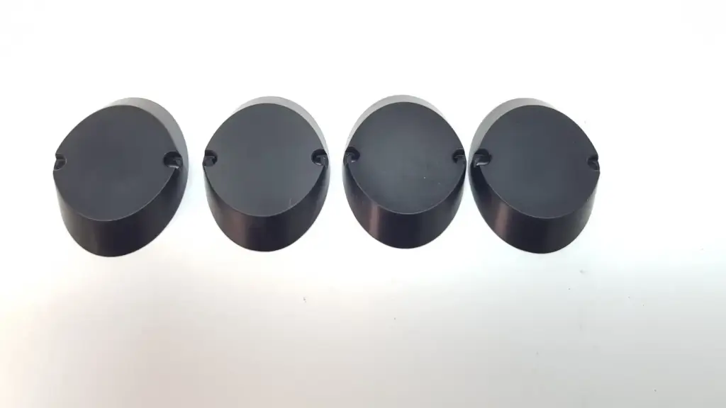 Four black Lumenis MM-1099640 final joint covers, top view showing the oval shape and rim notches