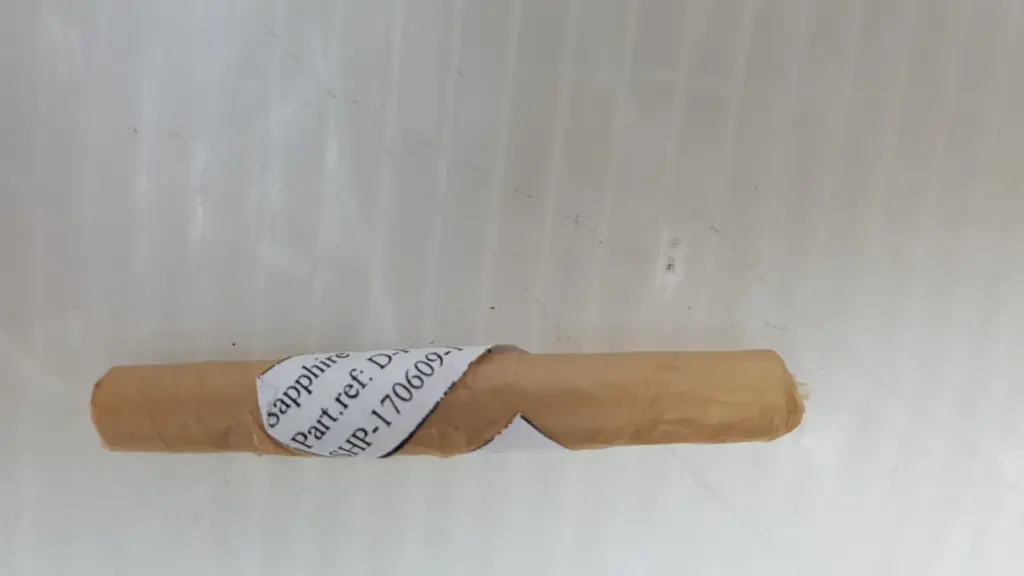 Paper-wrapped sapphire cylinder with a label reading Sapphire, Part ref and SHP-170609