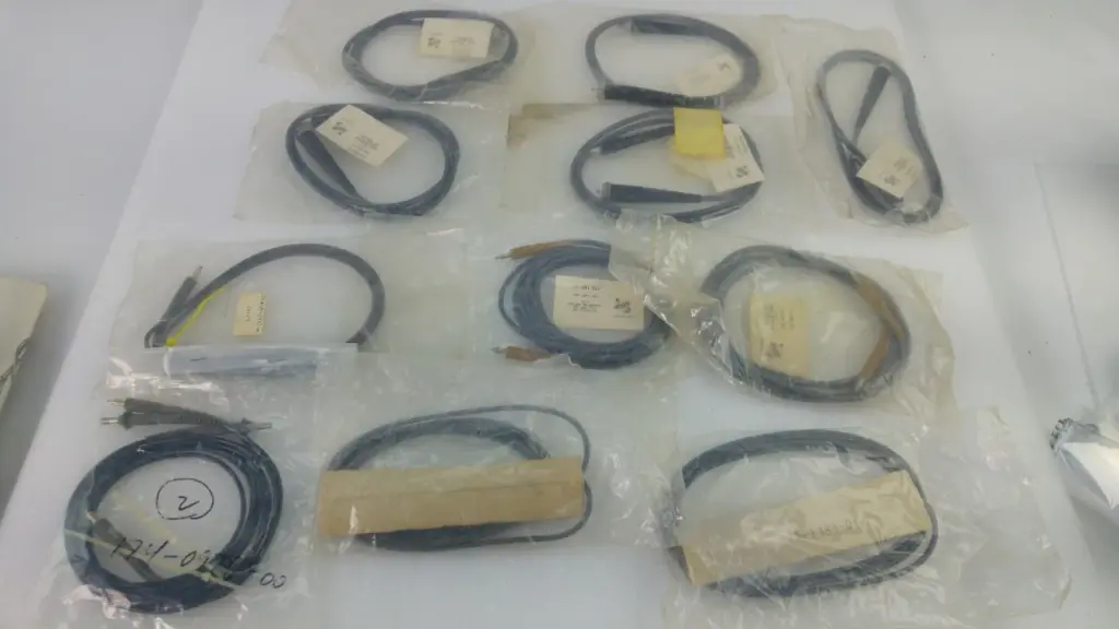 Lot of 11 Tektronix cable assemblies in their individual bags laid out together
