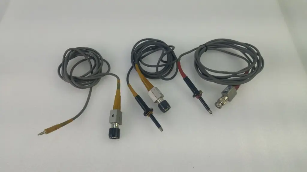 Three used Tektronix passive oscilloscope probes, two P6105 and one P6108, with grey cables