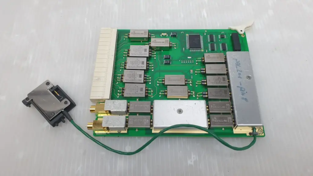 Agilent E3121-66611 pin board PCB with metal-can modules, two gold coax jacks and green lead to black connector