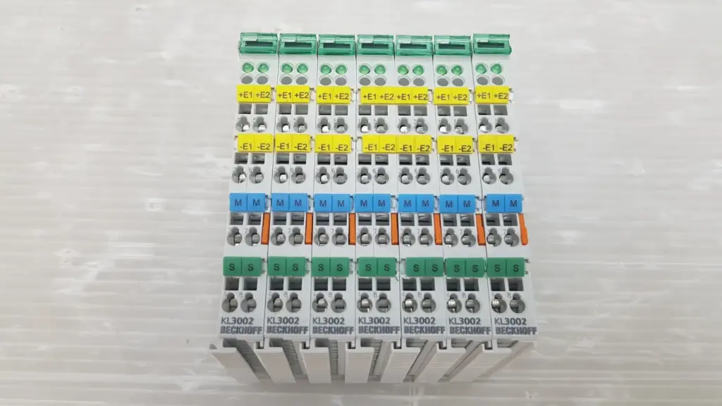 Seven Beckhoff KL3002 analog input terminals side by side with yellow, blue and green marker tags