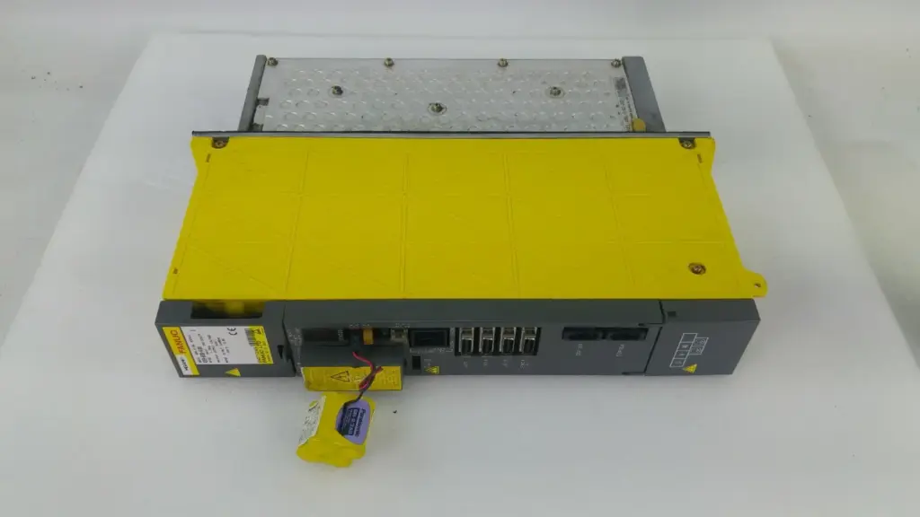 Fanuc A06B-6096-H104 servo amplifier module with yellow cover, heat sink and battery pack