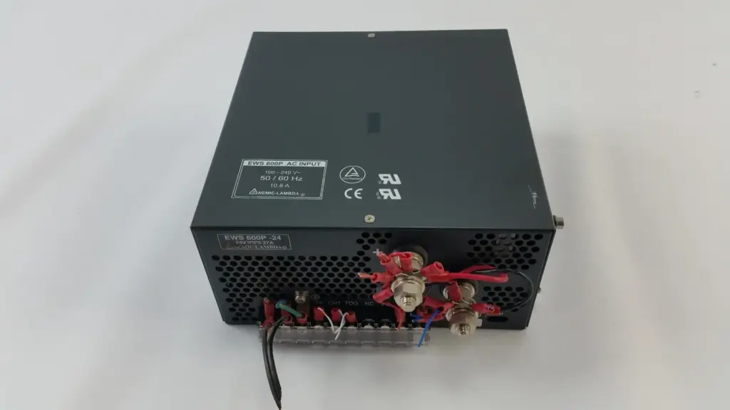 Nemic-Lambda EWS600P-24 power supply, top label and front with output studs and wired terminal strip