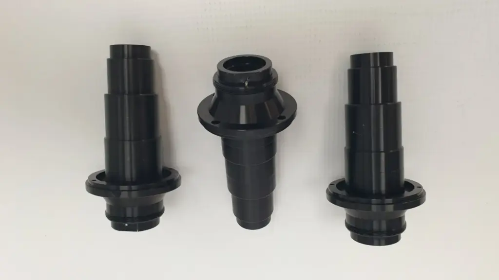 Three black optical adapters MM-20096330, side view with mounting flanges